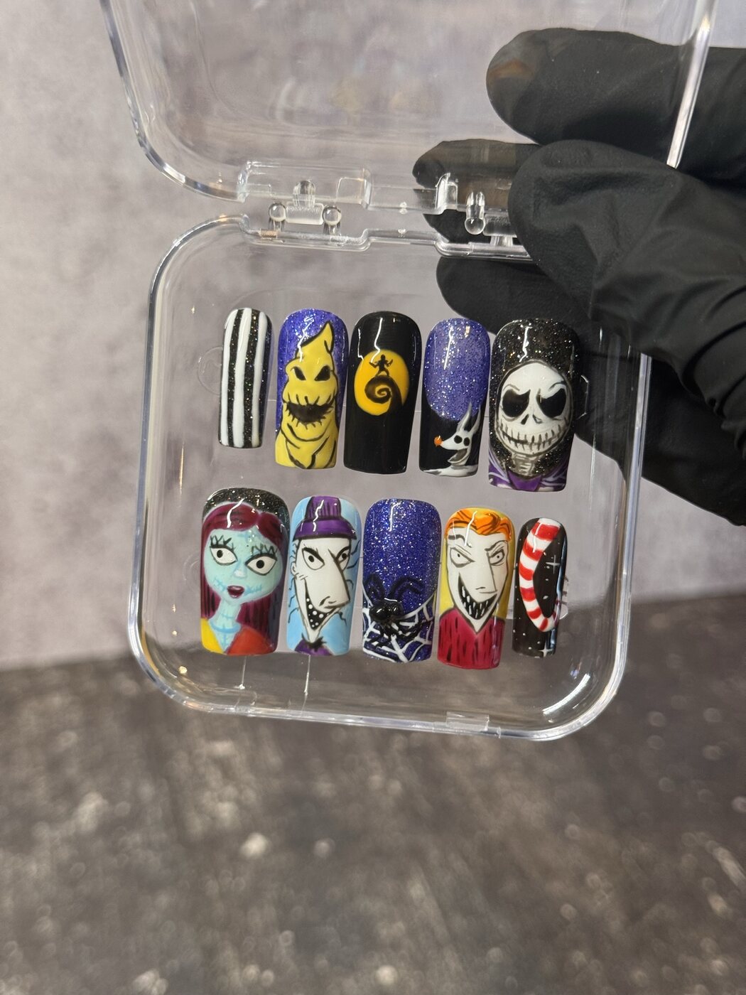 Handpainted press-on nails with illustrated Halloween characters, purple glitter and black-and-white stripes